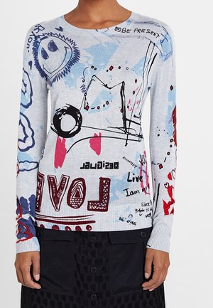 Koszula z długim rękawem z artystycznymi bazgrołami, uśmiechniętą buźką, czerwonymi i niebieskimi akcentami oraz napisami, w tym "LOVE" i "Bądź obecny", na jasnoszarym tle.