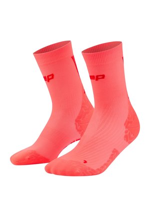 Paar leuchtend korallenfarbene Sportsocken bis zum Knöchel mit strukturierter Belüftung und roten Logo-Akzenten auf weißem Hintergrund.