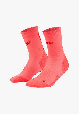Paar leuchtend korallenfarbene Sportsocken bis zum Knöchel mit strukturierter Belüftung und roten Logo-Akzenten auf weißem Hintergrund.