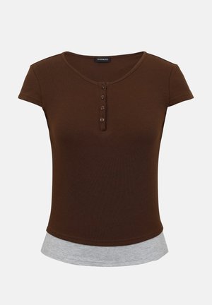 Lühikeste varrukatega pruun Henley-krae stiilis top, millel on neli nuppu ja alumisel serval nähtav halli kihiline ääre detail.