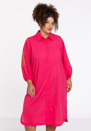 Rosa Hemdblusenkleid mit drei Viertelärmeln, das goldene Stickereien an den Ärmeln aufweist. Der Stoff hat eine glatte Textur und das Kleid hat einen knielangen Schnitt.