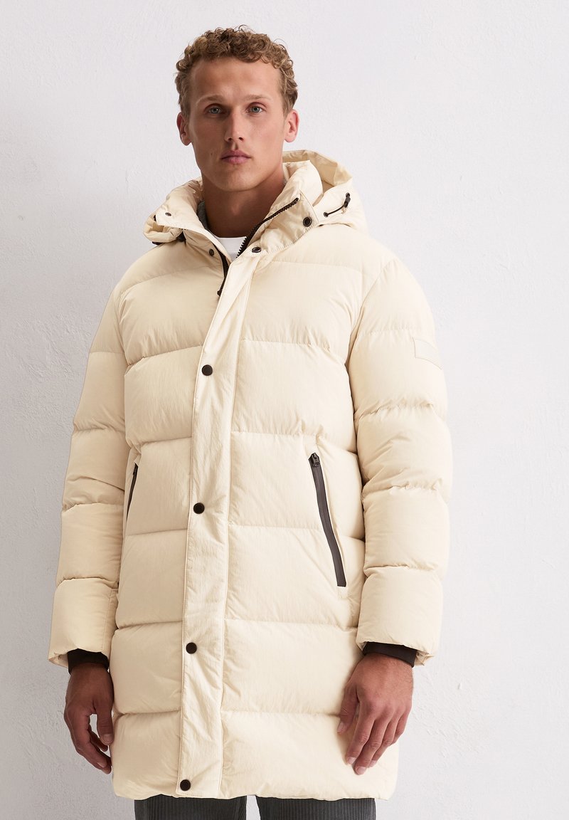 Pufferjack in off-white met een capuchon, voorzien van een horizontaal doorgestikt ontwerp, drukknoopsluiting aan de voorkant en twee zijritszakken.