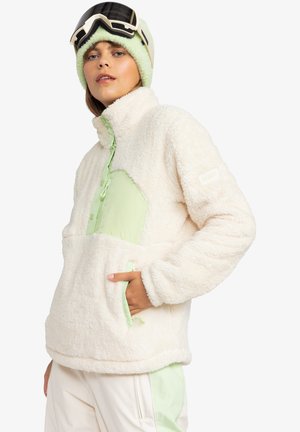 Fleece pullover in off-white with mint green accents, featuring a half-zip front, side pockets, and a soft textured finish.