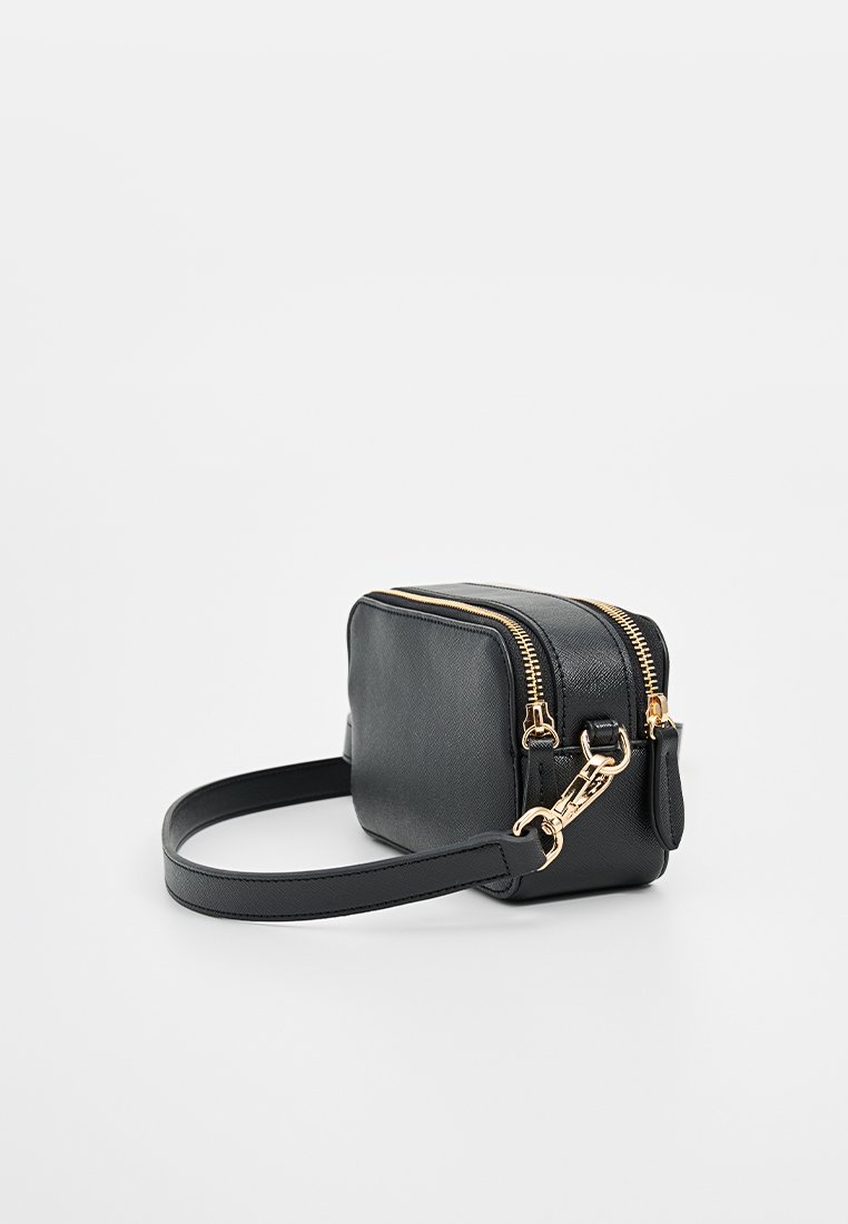 Czarna skórzana torba na ramię z dwiema zapinanymi na zamek komorami, złotymi akcentami i płaskim regulowanym paskiem. Gładka tekstura, kompaktowy prostokątny kształt.