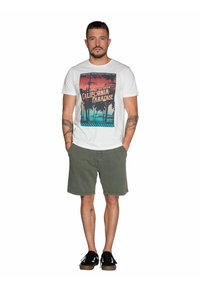 Witte t-shirt met korte mouwen met een kleurvolle "California Paradise" graphic. Olijfgroene shorts en zwarte schoenen maken de casual look compleet.