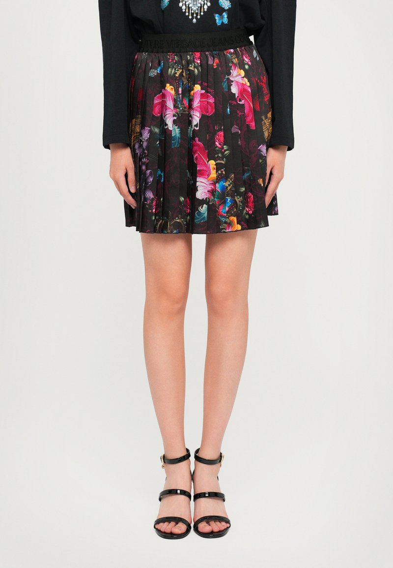 Falda plisada negra con un vibrante estampado floral en tonos de rosa, azul y amarillo, con una cintura marcada por la marca.