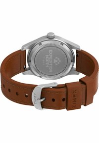 Timex Expedition North ur med et sølvfarvet rustfrit stålhus, brunt læderrem og tekstureret bagside med indgraverede logodetaljer.