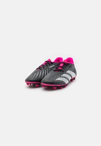 Scarpe da calcio nere con accenti rosa, dotate di una tomaia testurizzata, un motivo a punti in gradiente e chiusura tradizionale con lacci.
