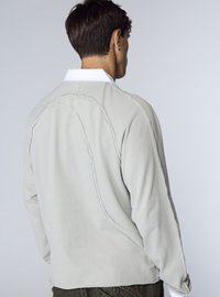 Felpa grigio chiaro a maniche lunghe con colletto bianco a contrasto, cuciture visibili e vestibilità comoda. Tessuto morbido e design semplice.