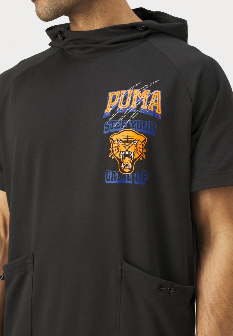 Sudadera negra con capucha, hecha de una tela suave y con dos bolsillos laterales. Presenta gráficos vibrantes en naranja y azul, incluyendo un tigre y el logo de la marca.