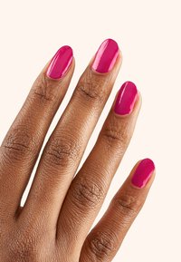Pięć palców z wypolerowanymi, błyszczącymi, intensywnie różowymi paznokciami na opalonej skórze. Ręka ukazuje widoczną strukturę skóry i drobne linie. Brak akcesoriów.