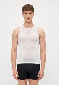 T-shirt de sport sans manches blanche avec des panneaux en mesh, présentant des motifs triangulaires et circulaires audacieux. Conception ajustée et texture lisse.