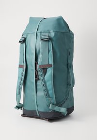 Teal backpack with a rolled top, adjustable straps, and a dark gray base. Features a textured surface and side pocket with a zipper.