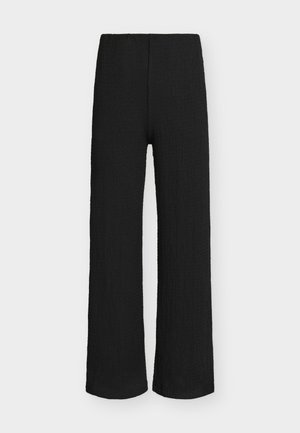 Pantalon large noir texturé avec taille élastique, présenté à plat sur un fond clair.