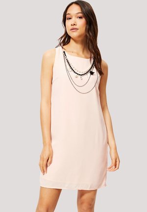 Vestido sin mangas de color rosa claro con corte recto, que presenta collares de cuentas negras y perlas en capas a lo largo del escote. Textura de tela suave.
