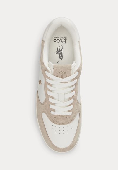 Valkoinen ja beige Polo Ralph Lauren -lenkkari, jossa rei'itetty varvasosa, valkoiset nauhat ja logo näkyvissä kielekkeessä ja pohjallisessa, nähtynä ylhäältä päin.