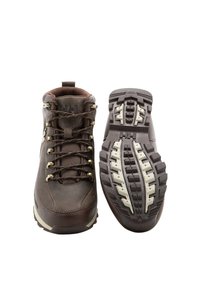 Botas de senderismo de cuero marrón con ojales de metal y cordones marrones. Suela de goma texturizada con surcos profundos para tracción y estabilidad.