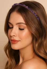 Fioletowa opaska na głowę z koralikami i przezroczystymi kamieniami, o zakrzywionym kształcie. Włosy falowane, o naturalnym wyglądzie i miękkim kolorze.