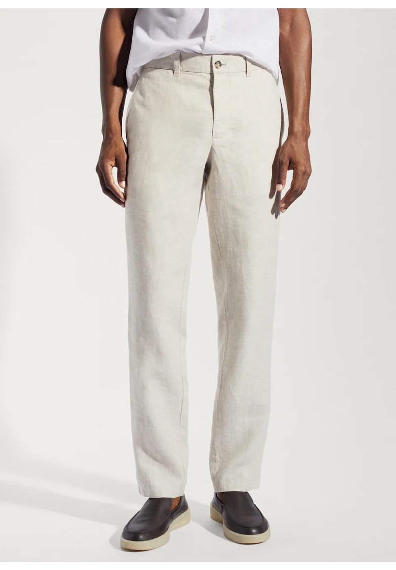 Pantaloni in lino beige chiaro con taglio dritto, chiusura con un singolo bottone frontale e tasche laterali, indossati con scarpe slip-on scure.