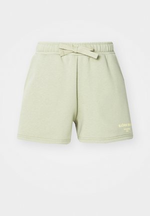 Svetlo zeleni bombažni šorti z elastičnim pasom in detajlom vezanja. Imajo rumen logotip na spodnjem desnem delu noge in šivane robove.