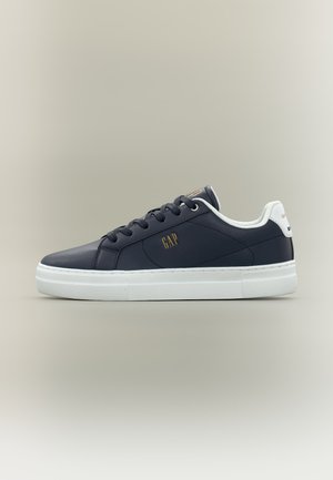 Juodi žemaitiški sportiniai bateliai su balta padu, raišteliais ir kulno kilpomis, ant šono ir kulno gale auksiniu „GAP“ logotipu.