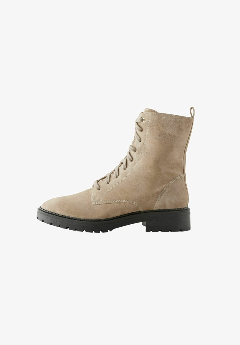 Beige nubukist kanna saabastega ümarate varvastega, nööridega ees ja musta kummitaldaga. Omab õmblemise detaile ja tõmbluku küljes taga.