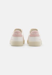 Hvite lær sneakers med lys rosa detaljer. Funksjoner inkluderer en teksturert hæl, logo bakpå og en beige gummisåle.
