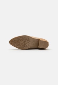 Suela de zapato de cuero beige con patrón floral, goma texturizada, tacón ligero y logo de marca en relieve. Acabado suave y duradero.