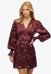 Vestido de satén burdeos con patrón floral, escote en V profundo, mangas abullonadas y frente con botones. Tejido texturizado con puños y dobladillo fruncidos.