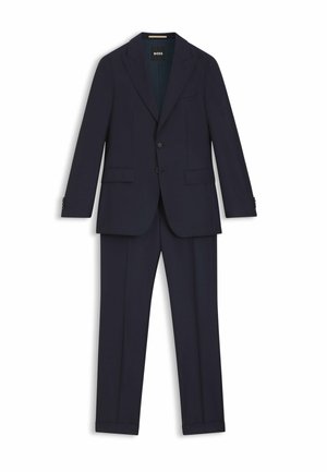 Completo blu navy con vestibilità su misura, fodera strutturata, giacca monopetto e pantaloni a pinces piatti. Presenta due tasche frontali e dettagli con bottoni.