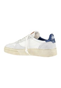 Sneaker in pelle e suede bianco con tallone blu navy, suola intermedia crema e lacci bianchi. Caratterizzato da una linguetta testurizzata e un piccolo logo sul retro.