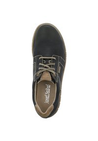 Scarpa in pelle nera con punta arrotondata, accenti beige e lacci. Presenta dettagli di cucitura e una suola testurizzata per una migliore aderenza. Nome del marchio visibile all'interno.