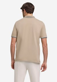 Beige polo shirt met korte mouwen van een textuurstof, voorzien van een contrasterende gestreepte kraag en manchetten, ontworpen voor een reguliere pasvorm.