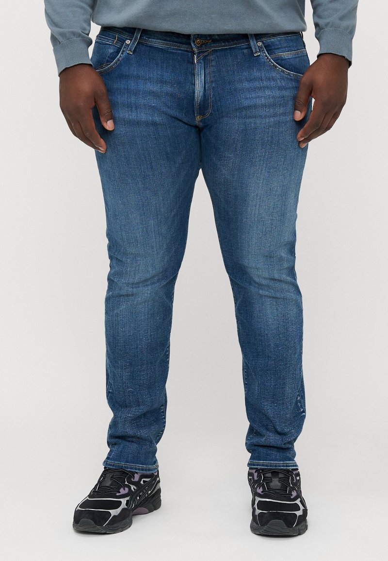 Blauwe denim jeans met een slim fit, voorzien van standaardzakken en een knoopsluiting. Het materiaal heeft een lichte textuur met subtiele vervagingen.