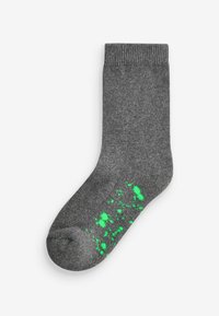 Chaussette en coton gris avec une bordure côtelée et un motif éclaboussé vert vif sur la moitié inférieure. Présente une texture lisse et une forme standard.