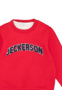 Red sweatshirt with ribbed crew neckline, featuring "JECKERSON" in black embroidered letters across the chest. Smooth texture.