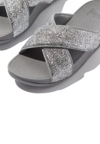 Grijze sandalen met een kruisbandontwerp, voorzien van een gestructureerd zilverkleurig bovenwerk, een zachte rubberen zool en een lichte boog voor comfort.