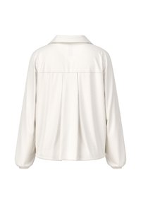 Weißes langärmliges Hemd mit Kragen, das ein geplätes Rückendesign und elastische Bündchen aufweist. Hergestellt aus weichem, strukturiertem Stoff.