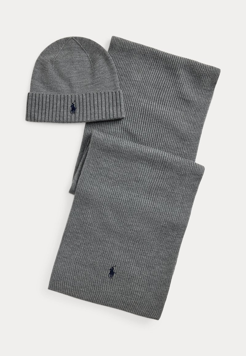 Gray knitted scarf and beanie set. The beanie has a ribbed edge, with a navy logo. Both items feature a textured pattern.