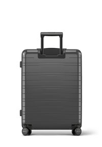 Valise rigide de couleur gris charbon mat avec un design texturé à rayures. Dotée d'une poignée noire rétractable et de quatre roues noires.