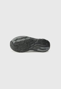 Semelle de chaussure en caoutchouc noir avec un motif texturé, présentant des formes arrondies et des rainures pour l'adhérence. Design plat, esthétique minimaliste.
