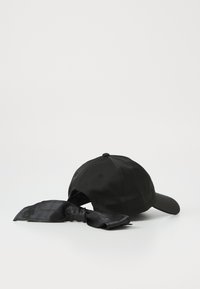 Cappellino da baseball nero con un nastro di tessuto satinato attaccato sul retro, caratterizzato da una superficie liscia e una visiera curva.