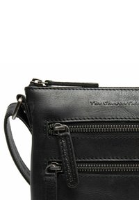 Schwarze Leder-Crossbody-Tasche mit mehreren Reißverschlusstaschen, glatter Textur, silbernem Zubehör und geprägtem Logo-Detail auf der Vorderseite.