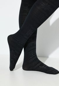 Collant neri con un motivo testurizzato di forme geometriche e motivi, con una finitura liscia e opaca e un design attillato.