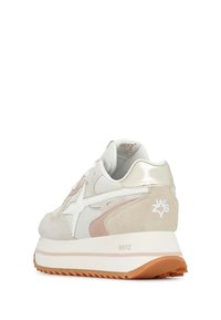 Sneaker con upper bianco e beige, realizzato in materiali scamosciati e in rete, con dettagli metallici e una suola in gomma testurizzata con bordi frastagliati.