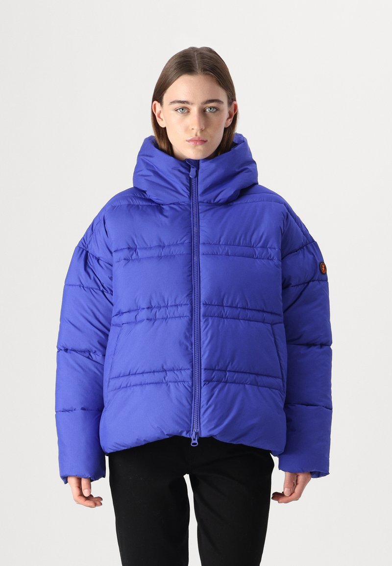 Lila Daunenjacke mit einer hohen, durchgängigen Kapuze, die horizontal genäht ist und eine lockere, übergroße Passform hat. Der Stoff wirkt glatt und gepolstert.