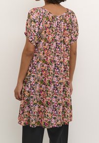 Blommig klänning med korta ärmar, rundad halsringning och lös passform. Färgerna inkluderar rosa, lila, grön och orange på en mörk bakgrund.
