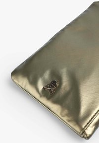 Clutch metallizzato oro con una superficie liscia, caratterizzato da un accento con teschio e tibie argentate nell'angolo inferiore. Forma rettangolare.