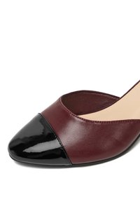 Bordowy skórzany but o zaokrąglonym nosku z czarną, lakierowaną skórzaną nakładką. Charakteryzuje się gładką fakturą i otwartymi bokami.