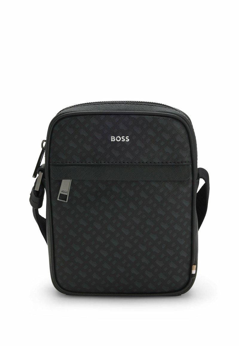 Black crossbody bag with a textured pattern, zip closure, and logo in silver. Features adjustable strap and front pocket detail.